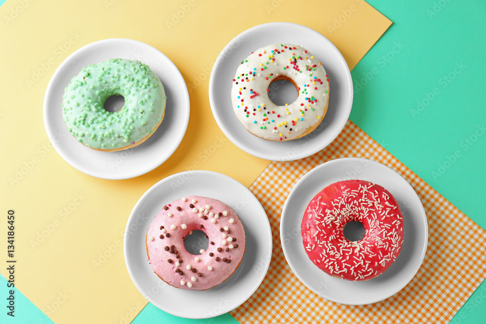 Sticker plates with delicious donut on colorful background