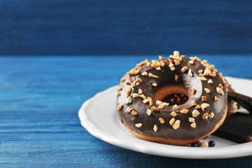 Tasty donuts with chocolate pieces on table