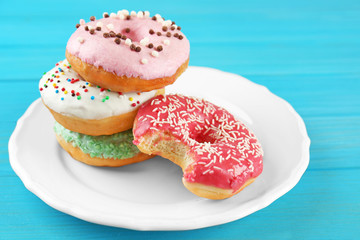 Plate with stack of delicious donuts, closeup