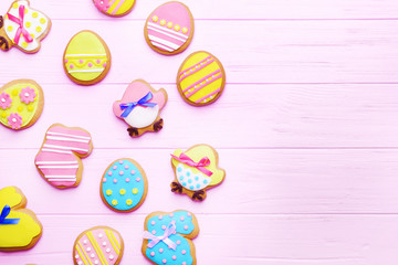 Decorative gingerbread Easter cookies on pink wooden background