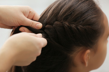 Woman doing hair of her daughter at home, closeup