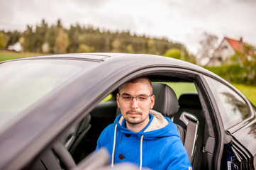 Naklejka premium Man in luxury coupe car