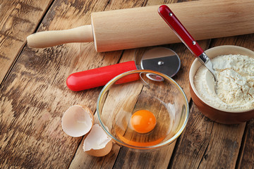 Food ingredients and kitchen utensils for cooking on wooden background