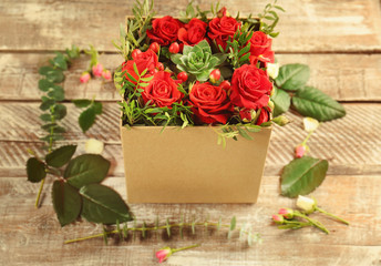 Beautiful roses in gift box on wooden background