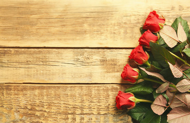 Naklejka na ściany i meble Bouquet of beautiful red roses on wooden background