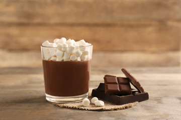 Chocolate mousse with marshmallows in portion glass on wooden background