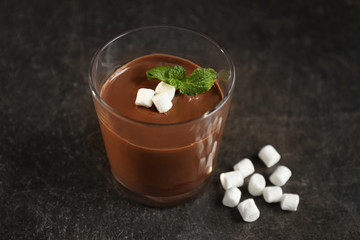 Chocolate mousse with marshmallows in portion glass on dark background