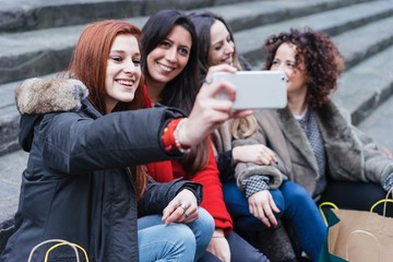 Happy female group of friends doing shopping together