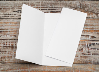 Bifold white template paper on wood texture .