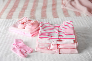 Set of baby clothes on bed