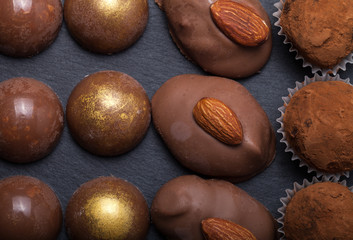 Different kinds of chocolate candies on a slate background