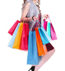 Woman's legs and shopping bags on light background