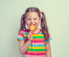 beautiful cute little girl eating lollipop