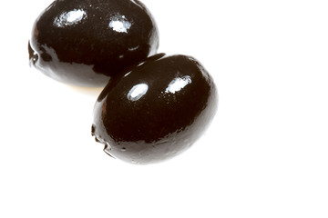 Ripe black olives on a white background