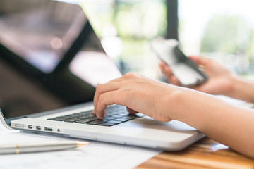 Closeup of business woman hand typing on laptop keyboard with mo