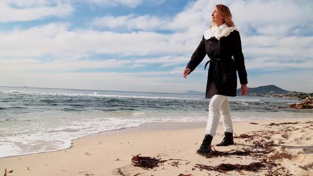femme seule se promenant sur la plage en hiver