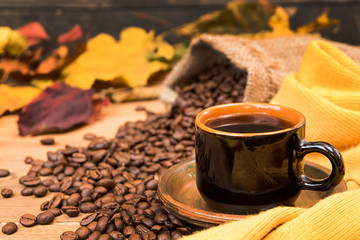 Cup of coffee, yellow scarf, roasted coffee beans
