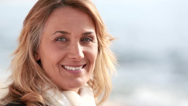 portrait de femme souriant qui regarde la mer