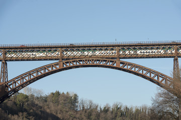 train passes on iron bridge over Adda river at Paderno, Italy
