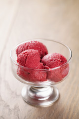 raspberry sorbet ice cream balls on wooden table, shallow focus