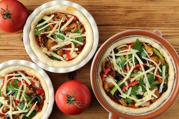 Casserole with mushrooms, olives, peppers and cheese on the dough for pizza.