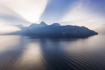 Alps of central Switzerland. Grand game of light and shadow. Sunlight sat behind a mountain ridge. Rays of light pierce the. Extra wide lens