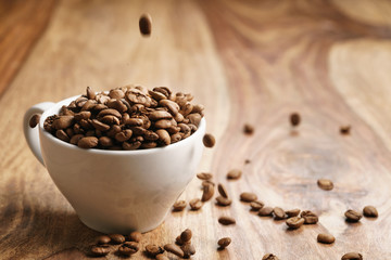 cappuccino cup with roasted coffee beans on wood table, with copy space