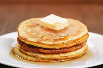 homemade pancakes with butter and maple syrup, closeup toned photo