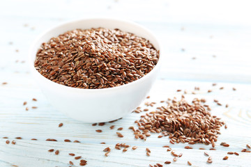 Brown flax seeds on white wooden table