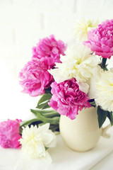Bouquet of pink and white peony flowers on brick wall background
