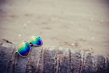 Fototapeta na wymiar Sunglasses on the beach with die coconut tree.
