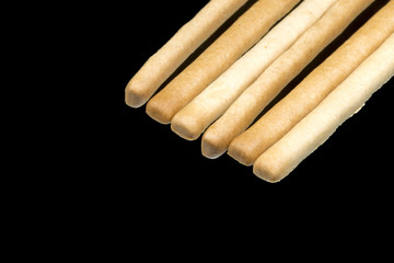 Delicious crispy pastry sticks isolated on black