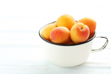 Ripe apricots fruit on white wooden table