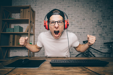 Young man playing game at home and streaming playthrough or walkthrough video