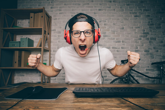 Young man playing game at home and streaming playthrough or walkthrough video