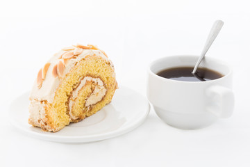 Almond roll cake on white dish with hot drink