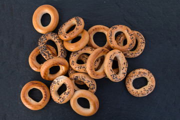 Bread bagels on a black slate, Russian sushki, simple dessert for tea ceremony and beer party. Wide panoramic image.