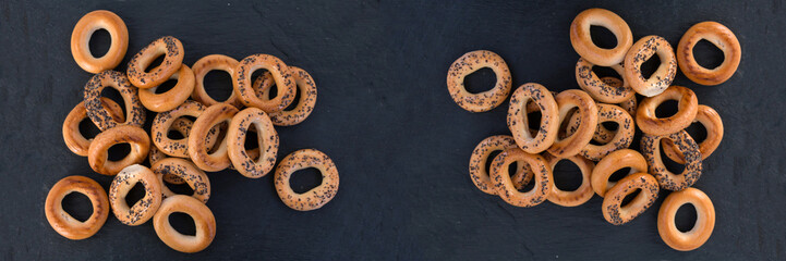 Bread bagels on a black slate, Russian sushki, simple dessert for tea ceremony and beer party. Wide panoramic image.