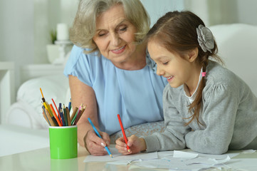 Happy Grandmother with granddaughter drawing