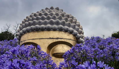 Amazing Sculptured Buddha surrounded by flowers
