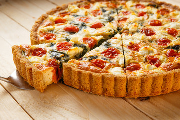 Vegetarian homemade pie, Quiche with tomatoes, spinach and feta cheese.