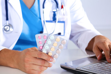 Fototapeta premium young doctor holds the patient's hand with pills