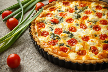 Vegetarian homemade pie, Quiche with tomatoes, spinach and feta cheese.