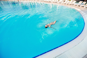 woman swimming on a blue water pool