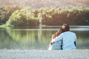 Naklejka na ściany i meble Valentine couple sit at riverside in garden while sunset.