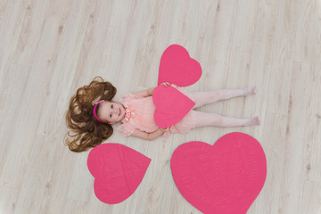 Sweet girl lying on the floor with decorations in the form of he