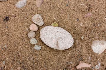 Fototapeta na wymiar trace feet made of a pebble stone close up on the sea sand deser