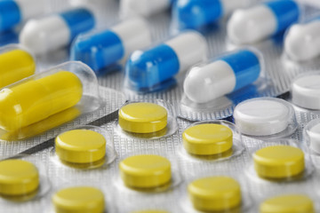 Boxes with yellow medical pills and blue-white pills