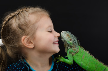 Perfect portrait little girl and green iguana      