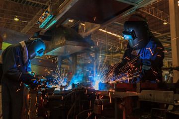 Team welders are welding in factory